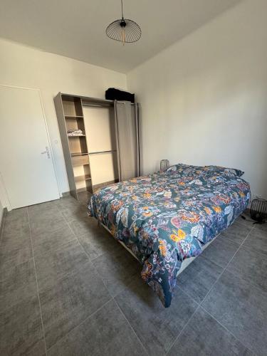 une chambre avec un lit avec une couette colorée dans l'établissement Appartement Cagne-sur-Mer, à Cagnes-sur-Mer