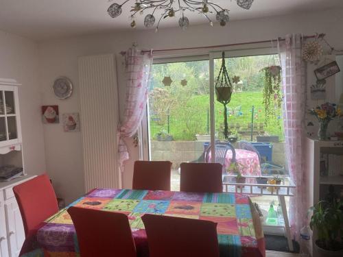 une salle à manger avec une table et des chaises et une fenêtre dans l'établissement Maison récente au coeur du village historique, à Locronan