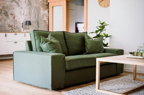 a green couch in a living room with a table at Fewo Waldfeeling in Brilon