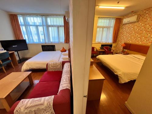 a room with two beds and a couch in it at Home Inn Beijing Xiaoxitian in Beijing