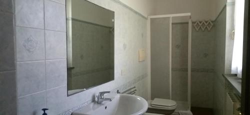 a bathroom with a sink and a toilet and a mirror at Hotel Il Cipresso in Capalbio