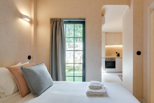 a bedroom with a white bed with a large window at Figueirôa Four Houses by DA'Home in Porto
