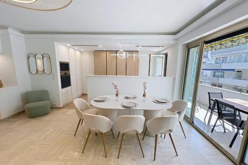 une salle à manger avec une table et des chaises blanches dans l'établissement Wide and sunny 3 BR 2 Baths heart of Cannes gorgeous terrace city ctr, à Cannes