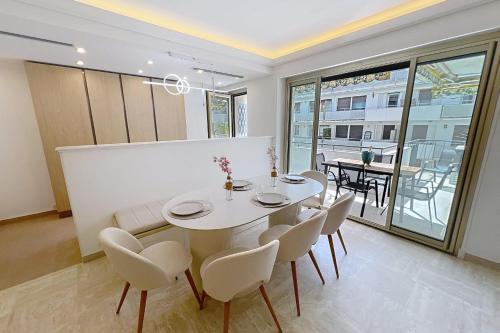 une salle à manger avec une table et des chaises blanches dans l'établissement Wide and sunny 3 BR 2 Baths heart of Cannes gorgeous terrace city ctr, à Cannes
