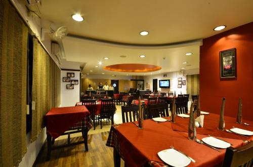 a dining room with tables and chairs in a restaurant at Hotel Rajawas in Dibrugarh