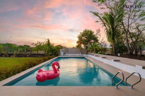 a swimming pool with a pink rubber duck in the water at EKOSTAY - White Lotus in Karjat