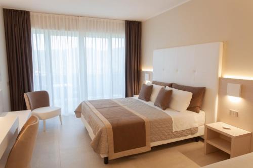 a hotel room with a large bed and a table at Hotel La Perla Del Golfo in Procchio