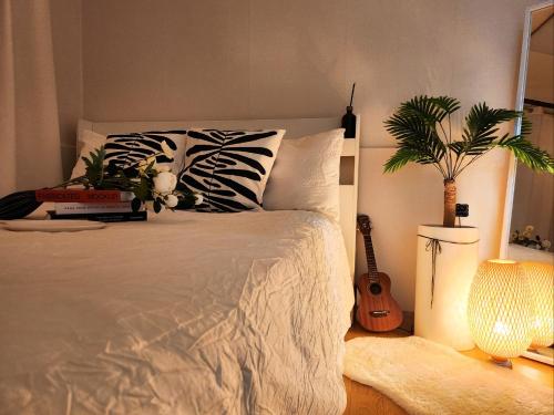 a bedroom with a bed with a guitar and a plant at Eunyoung Stay in Suwon