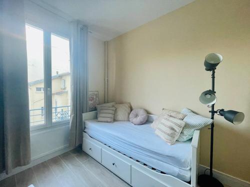 - une petite chambre avec un lit et une fenêtre dans l'établissement Cozy renovated studio, à Montrouge