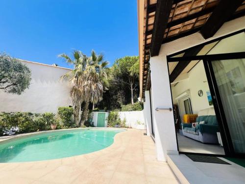 une villa avec une piscine à côté d'une maison dans l'établissement Villa Pinede - VILLA de vacances au calme avec espace piscine MAE-0461, à La Grande Motte