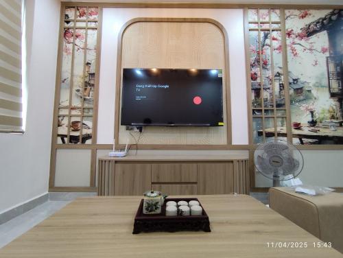 a living room with a flat screen tv on a wall at Nhà Nắng Vàng in Hai Phong