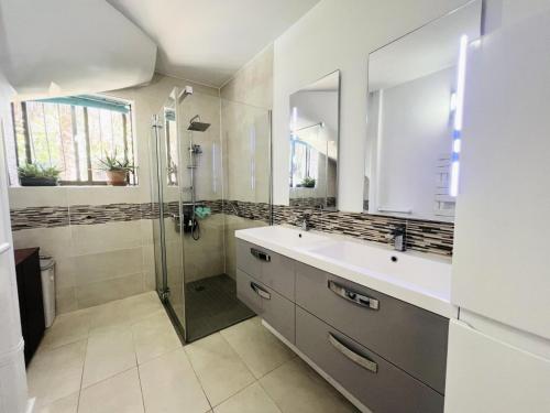 une salle de bain avec un lavabo et une douche dans l'établissement Villa Pinede - VILLA de vacances au calme avec espace piscine MAE-0461, à La Grande Motte