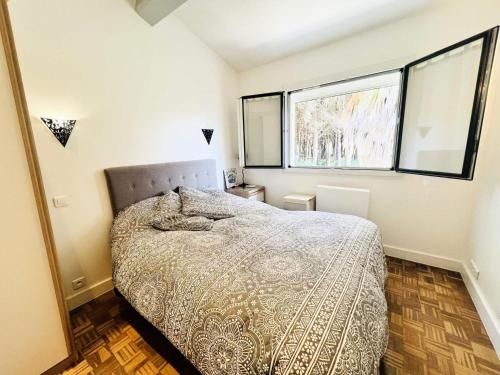 une chambre avec un lit et deux fenêtres dans l'établissement Villa Pinede - VILLA de vacances au calme avec espace piscine MAE-0461, à La Grande Motte