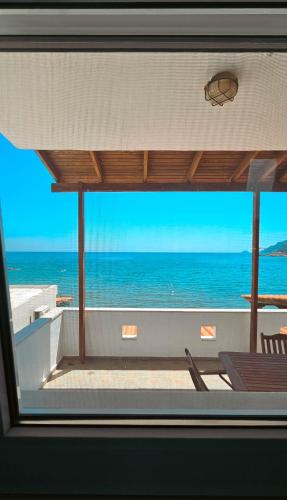 a view of the ocean through a window at Waves Melody in Kómi