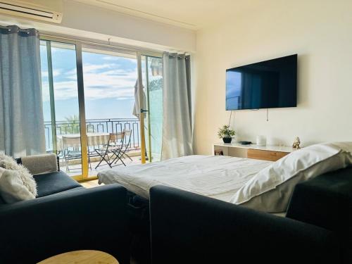- une chambre avec un lit, une télévision et un balcon dans l'établissement Nice apartment with sea view on Promenade Anglais, à Nice