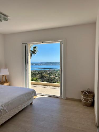 - une chambre avec une porte coulissante en verre offrant une vue sur l'océan dans l'établissement Villa ALFALINE, à Port Grimaud