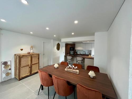 a kitchen and dining room with a wooden table and chairs at Durbuy, l Olivier, Maison charmante 4 façades en pierre du pays in Durbuy