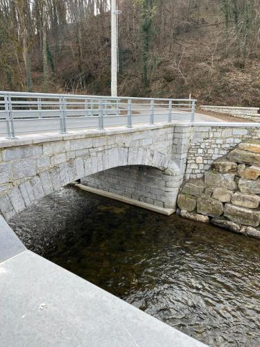 a stone bridge over a river with a road at Durbuy, l Olivier, Maison charmante 4 façades en pierre du pays in Durbuy