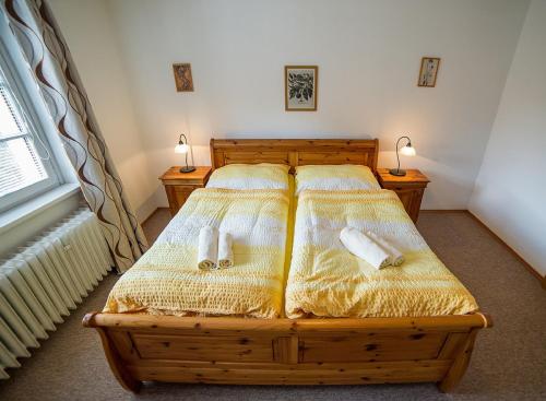 a bedroom with a wooden bed with two twin beds at Pension Jana in Český Krumlov