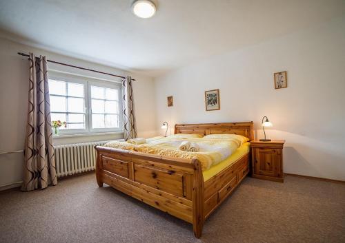 a bedroom with a large wooden bed and a window at Pension Jana in Český Krumlov