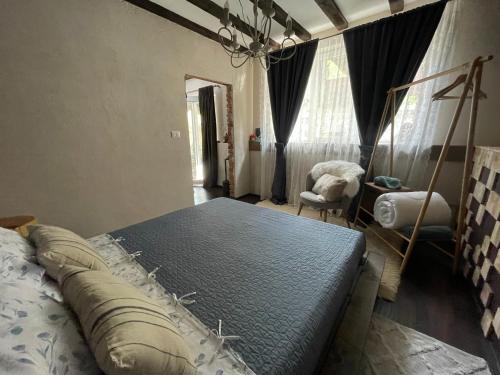 a bedroom with a large bed and a chair at Къща за гости Mia Maria in Tutrakan
