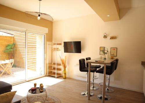 un salon avec une table et des chaises dans l'établissement Le Moment Bien-Être - jacuzzi privatif, terrasse et parking gratuit au centre de Saint-Omer, à Saint-Omer