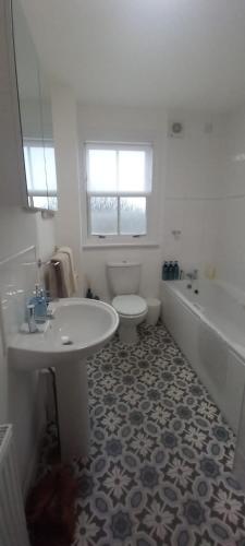 a bathroom with a tub and a toilet and a sink at Idyllic Waterside Penthouse in Callander
