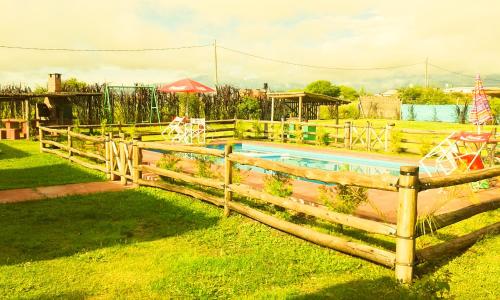 a wooden fence around a pool in a yard at Cabañas Villa del Sol in Salta
