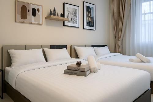 two beds sitting next to each other in a bedroom at GM5 - Cozy Apartment 8pax, Ladprao, MRT&BTS in Bangkok