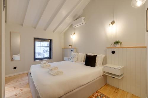 une chambre avec un grand lit blanc dans une pièce dans l'établissement Figueirôa Four Houses by DA'Home, à Porto