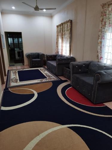 a living room with couches and a carpet at Guest house sri purnama banggol in Kota Bharu