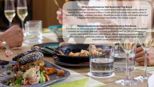 a table with a plate of food and glasses of wine at MYND Adeje in Adeje