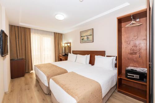 a hotel room with a large bed and a television at Askoc Hotel & SPA in Istanbul