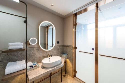 a bathroom with a sink and a shower at Mercure Qingdao Downtown in Qingdao