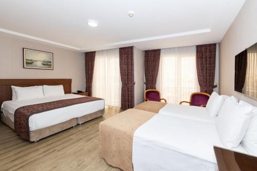 a hotel room with two beds and curtains at Askoc Hotel & SPA in Istanbul