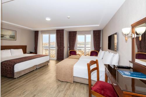 a hotel room with two beds and a balcony at Askoc Hotel & SPA in Istanbul