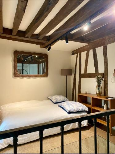 une chambre avec un lit et un miroir dans l'établissement Maison à Saint-Germain-des-Prés, à Paris