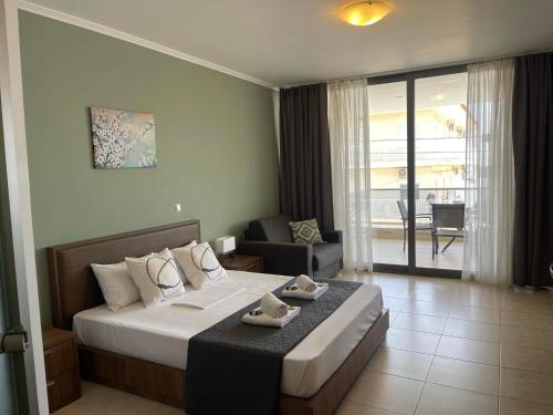 a hotel room with a bed and a balcony at Centrum Rooms in Kallithea Halkidikis