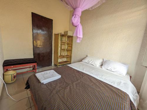 a bedroom with a large bed with a pink ceiling at Randa's House I Homestay in Ruhengeri