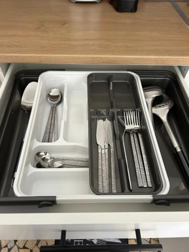 un tiroir rempli d'ustensiles dans un réfrigérateur dans l'établissement Appartement, à Decazeville