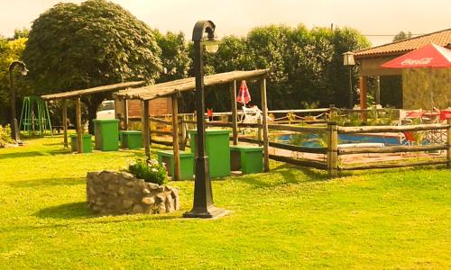 a light pole in the grass next to a playground at Cabañas Villa del Sol in Salta