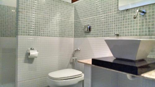 La salle de bains est pourvue de toilettes et d'un lavabo. dans l'établissement Pousada Aruana, à Canoa Quebrada