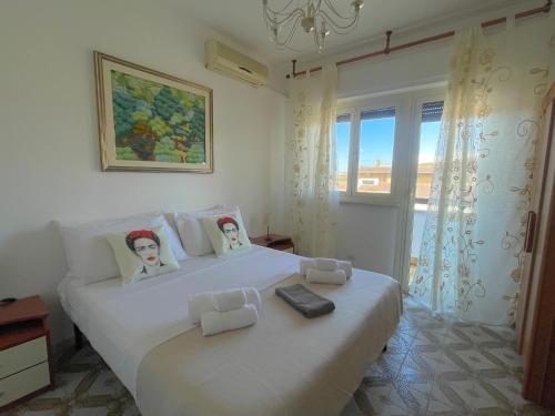 a bedroom with a white bed with two dolls on it at FELYX APARTMENT - Bright, Spacious, and 100 mt from the waves - Lavinio Mare in Anzio