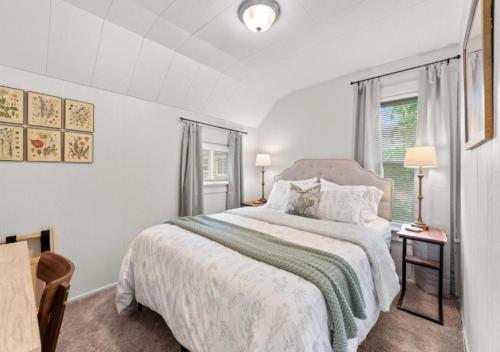 a white bedroom with a bed and a window at Double the Space for Large Groups Entire Duplex in Cleveland