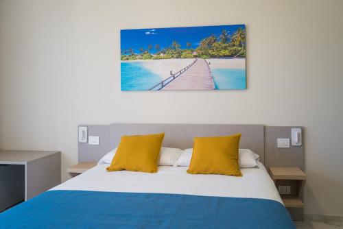 a bedroom with a bed with yellow pillows at Relais Villa Ottavia in Bitonto