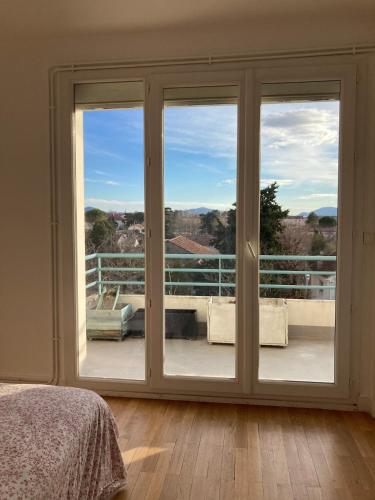 - une chambre avec une grande porte coulissante en verre dans l'établissement Grand appartement lumineux avec vue sur l'Ardèche, à Montélimar