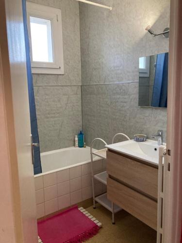 une salle de bain avec une baignoire et un lavabo et une baignoire dans l'établissement Grand appartement lumineux avec vue sur l'Ardèche, à Montélimar