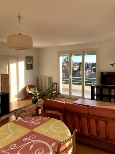 un salon avec un canapé et une table dans l'établissement Grand appartement lumineux avec vue sur l'Ardèche, à Montélimar