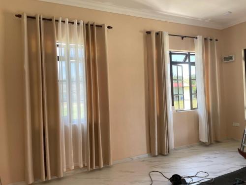 a living room with curtains and a window at Rumah Singgah in Kampong Tengah