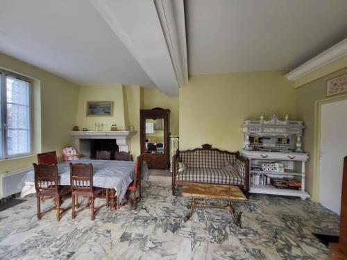 un salon avec une table et des chaises et une cheminée dans l'établissement Les Hortensias, à Chisseaux